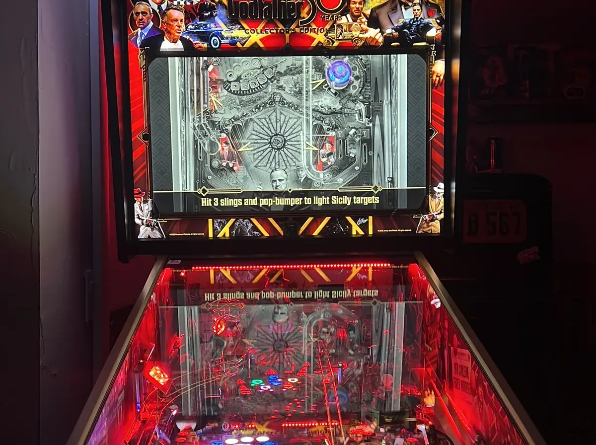 Customer test-playing a pinball machine on the showroom floor